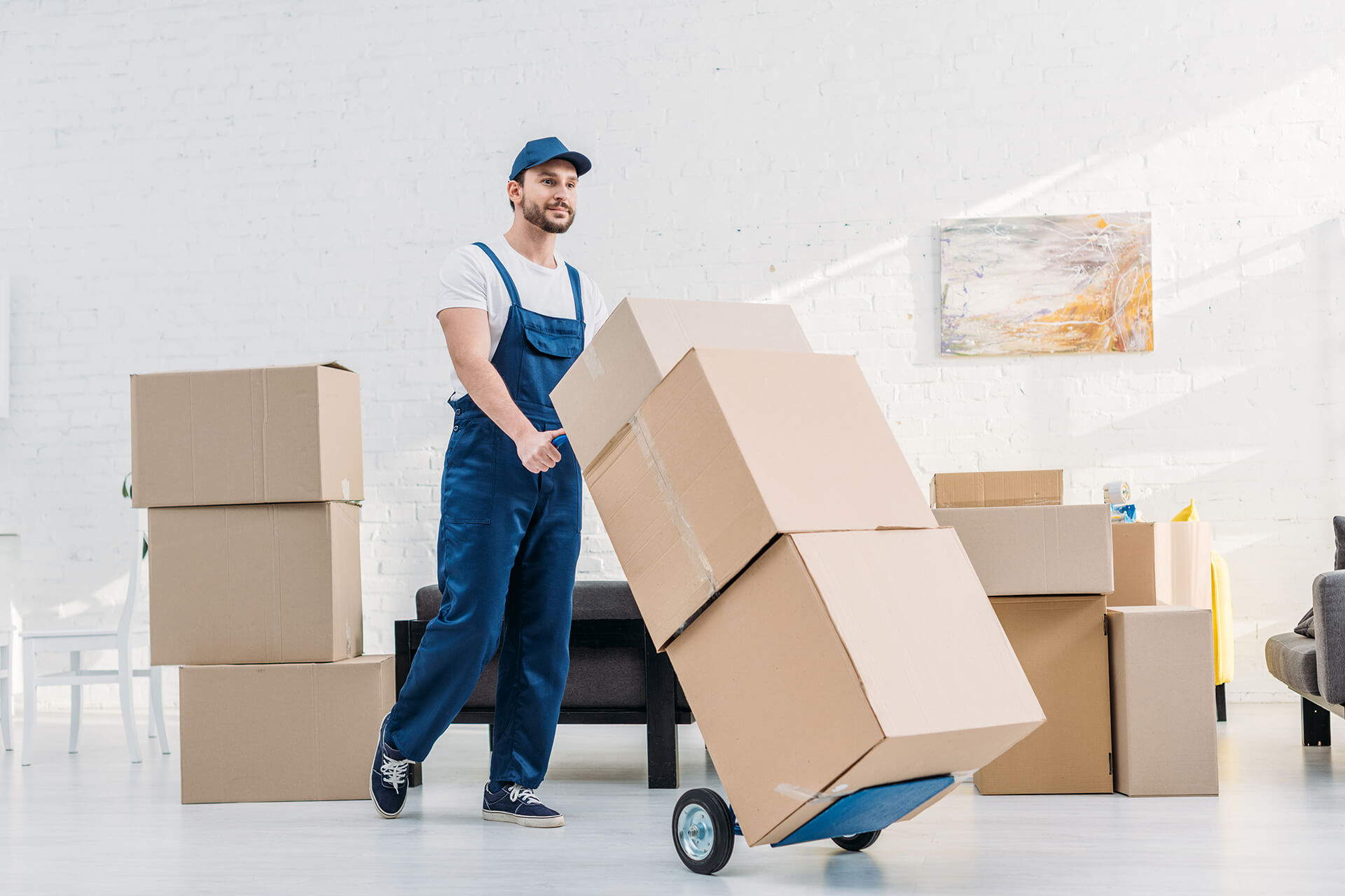 mover-in-uniform-transporting-cardboard-boxes-on-X6KAQDN.jpg